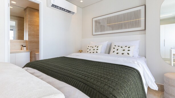 A modern bedroom with a large bed, a bedside table, a mirror, and a framed artwork on the wall. - Riverside HOUSI by Carpediem em Recife (Recife)