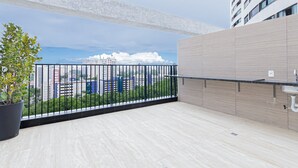 A balcony with a city view, a potted plant, and a modern building facade. - Riverside HOUSI by Carpediem em Recife (Recife)