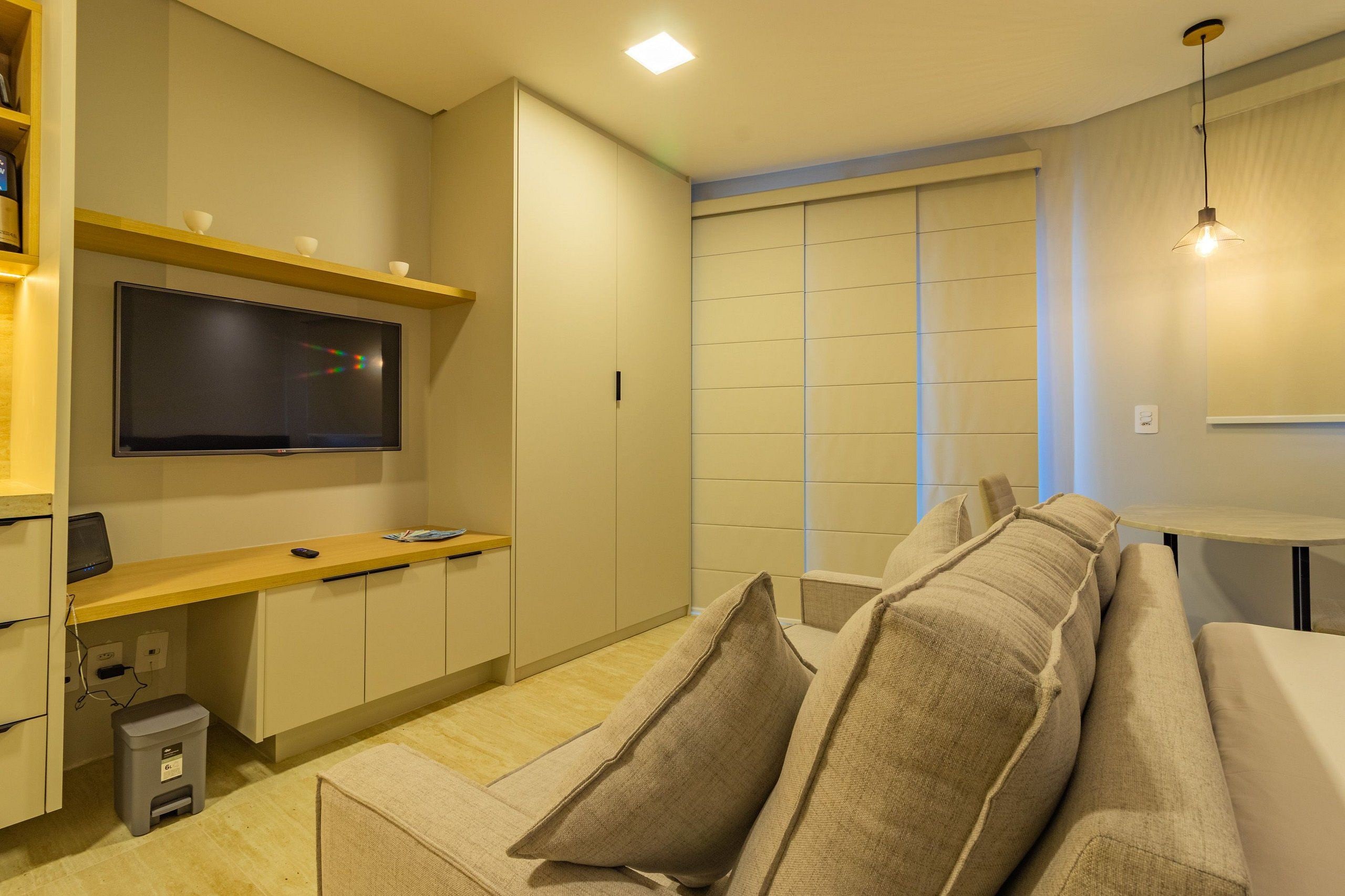 Una sala de estar moderna con un sofá, televisor y una mesita.