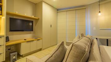 Una sala de estar moderna con un sofá, televisor y una mesita.