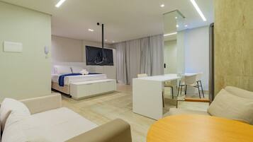 Una habitación de hotel moderna con cama, escritorio, silla y sofá.