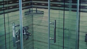 A glass-enclosed shower with a tiled floor and a metal handle. - Richard place otel apart (Marmaris)
