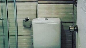 A bathroom with a toilet, a towel rack, and a door with a handle. - Richard place otel apart (Marmaris)