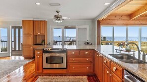 A spacious kitchen with wooden cabinets, a stainless steel oven, and a large island with a sink.