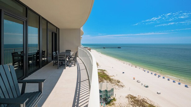 A balcony with a view of the beach and ocean.
