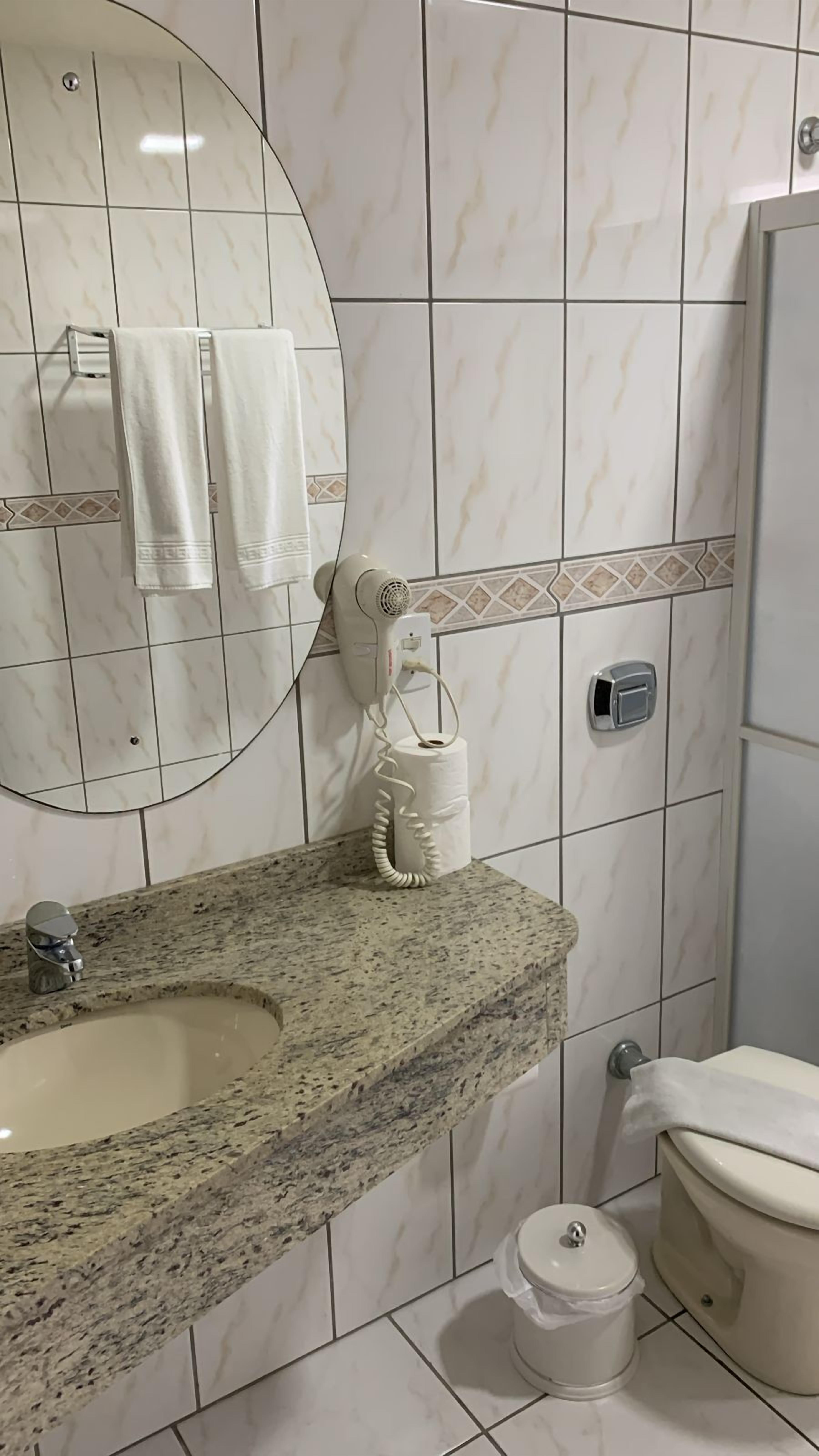 Un bagno con lavandino in granito, un water, un bidet e un porta asciugamani.