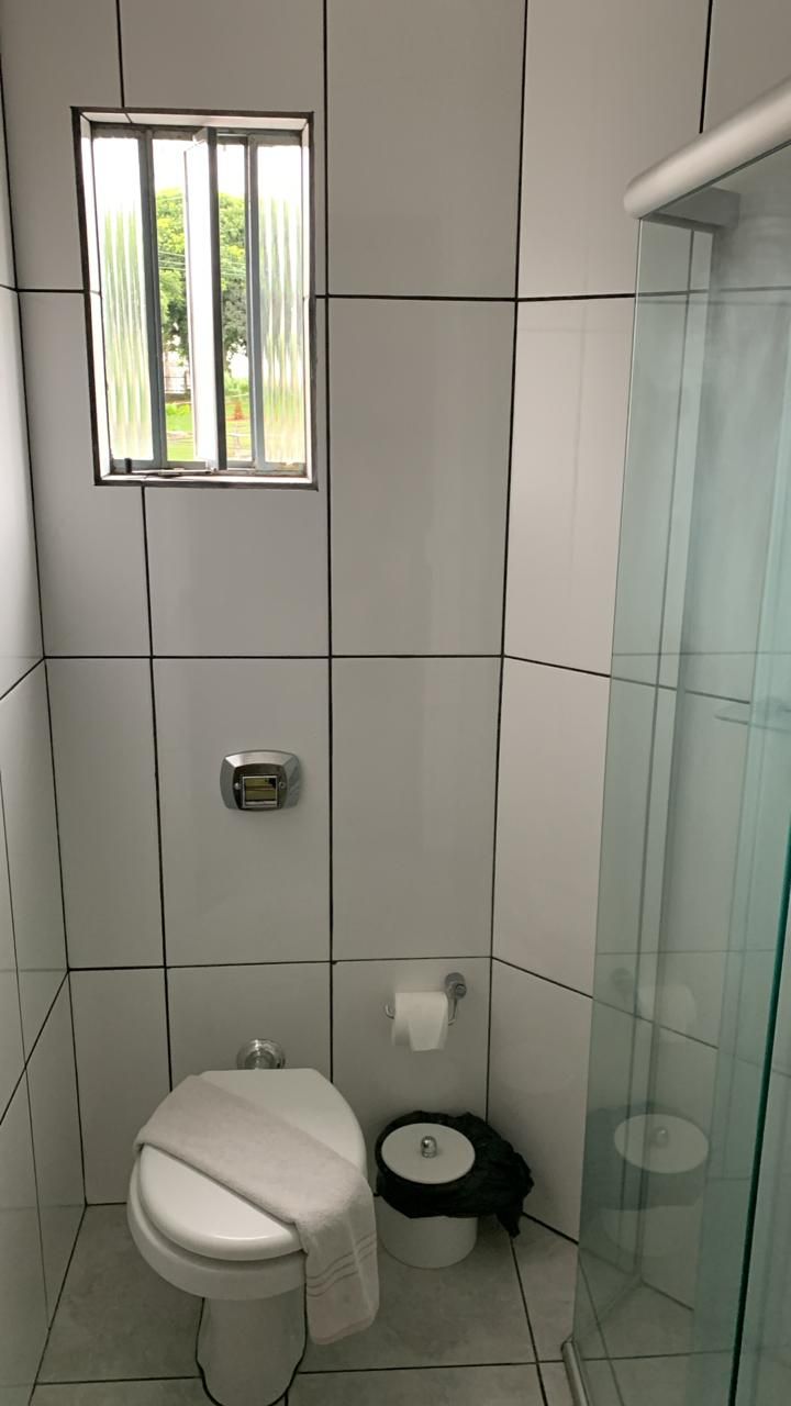 A modern bathroom with a toilet, bidet, and a glass shower enclosure.