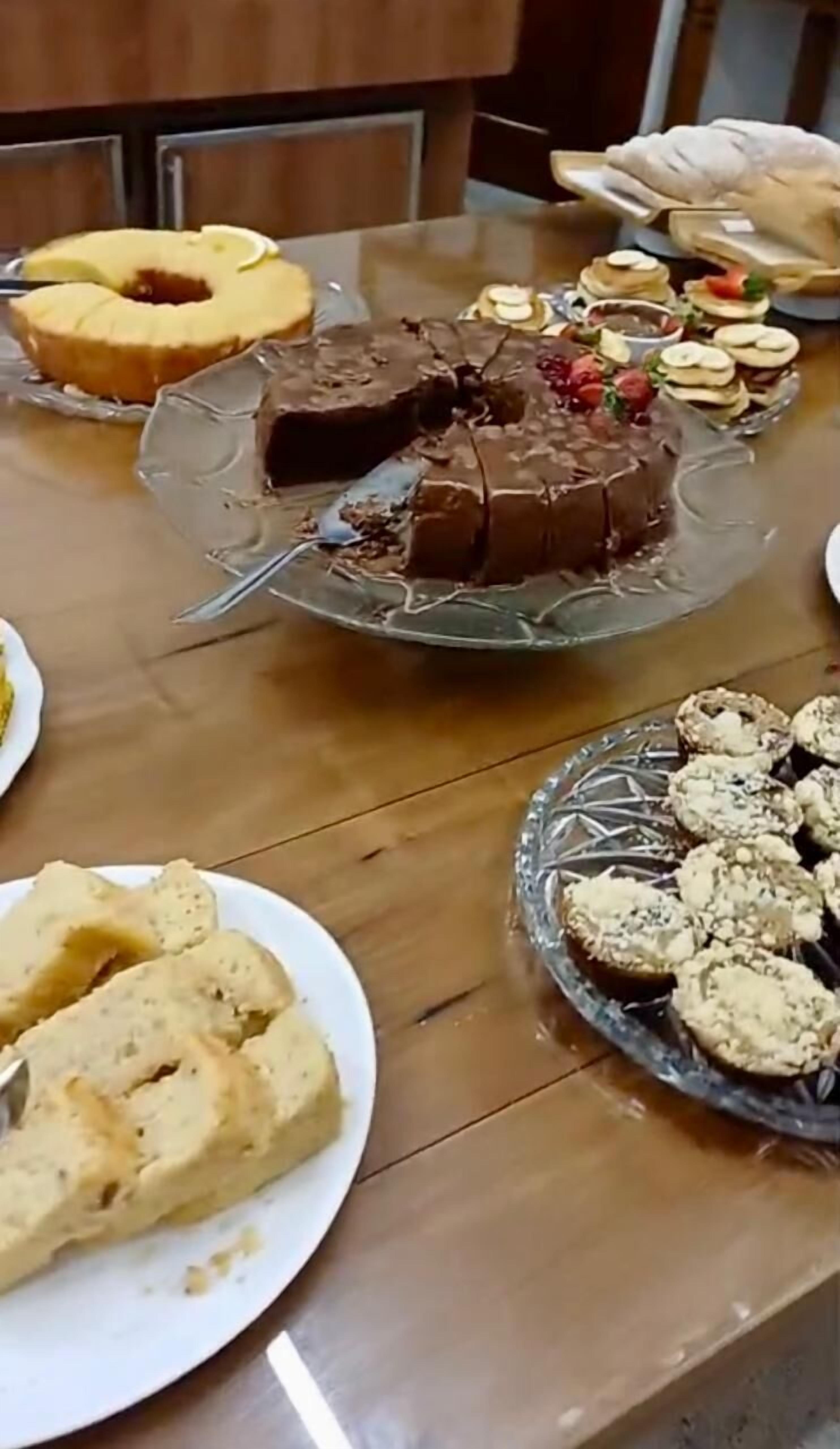 A dining table with various desserts including a cake, cookies, and pastries.