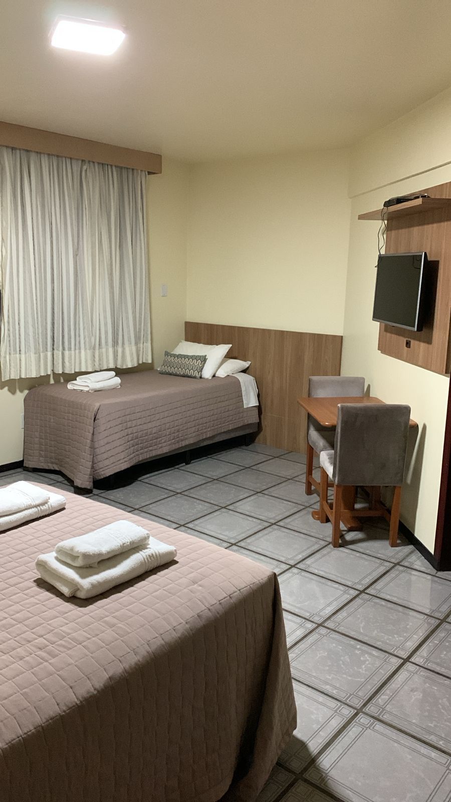 Ein Hotelzimmer mit einem Bett, einem Schreibtisch und einem Fernseher.