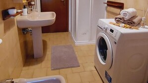 A compact bathroom with a sink, bidet, and washing machine. - Casa Pisani - Two Bedroom Apartment, Sleeps 6 (Rimini)
