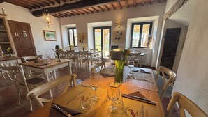 Un restaurante con mesas y sillas de madera, menús del día y copas de vino.