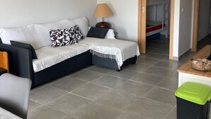 A modern living room with a sectional sofa, a small table, and a lamp. - Alvor T1 1 Flat in Portim o (Portimão)