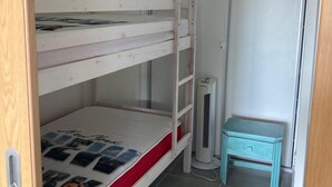 A bunk bed room with a small table and a heater. - Alvor T1 1 Flat in Portim o (Portimão)