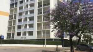 Un edificio de varios pisos con un diseño arquitectónico moderno, con balcones y grandes ventanales.