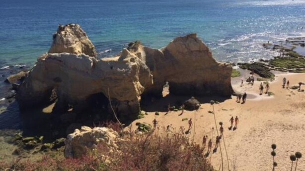 Un paisaje costero con formaciones rocosas y una playa arenosa.