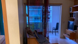 A living room with a wooden sofa, a television, and a bookshelf. - Faia Praia da Rocha Pool Terrace Flat (Portimão)