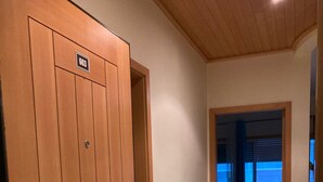 A hallway with a wooden door labeled "603" leading to a room with a bed and a view of the outside. - Faia Praia da Rocha Pool Terrace Flat (Portimão)