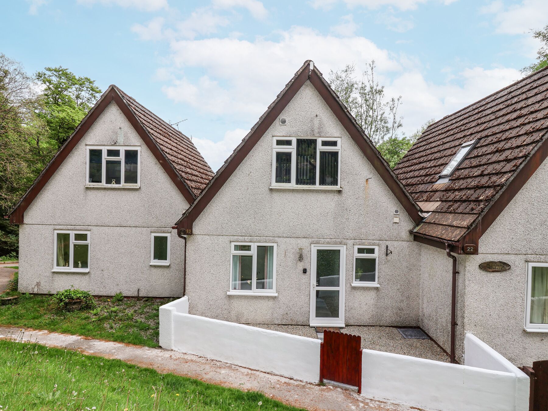 A row of two-story houses with pitched roofs and white walls.