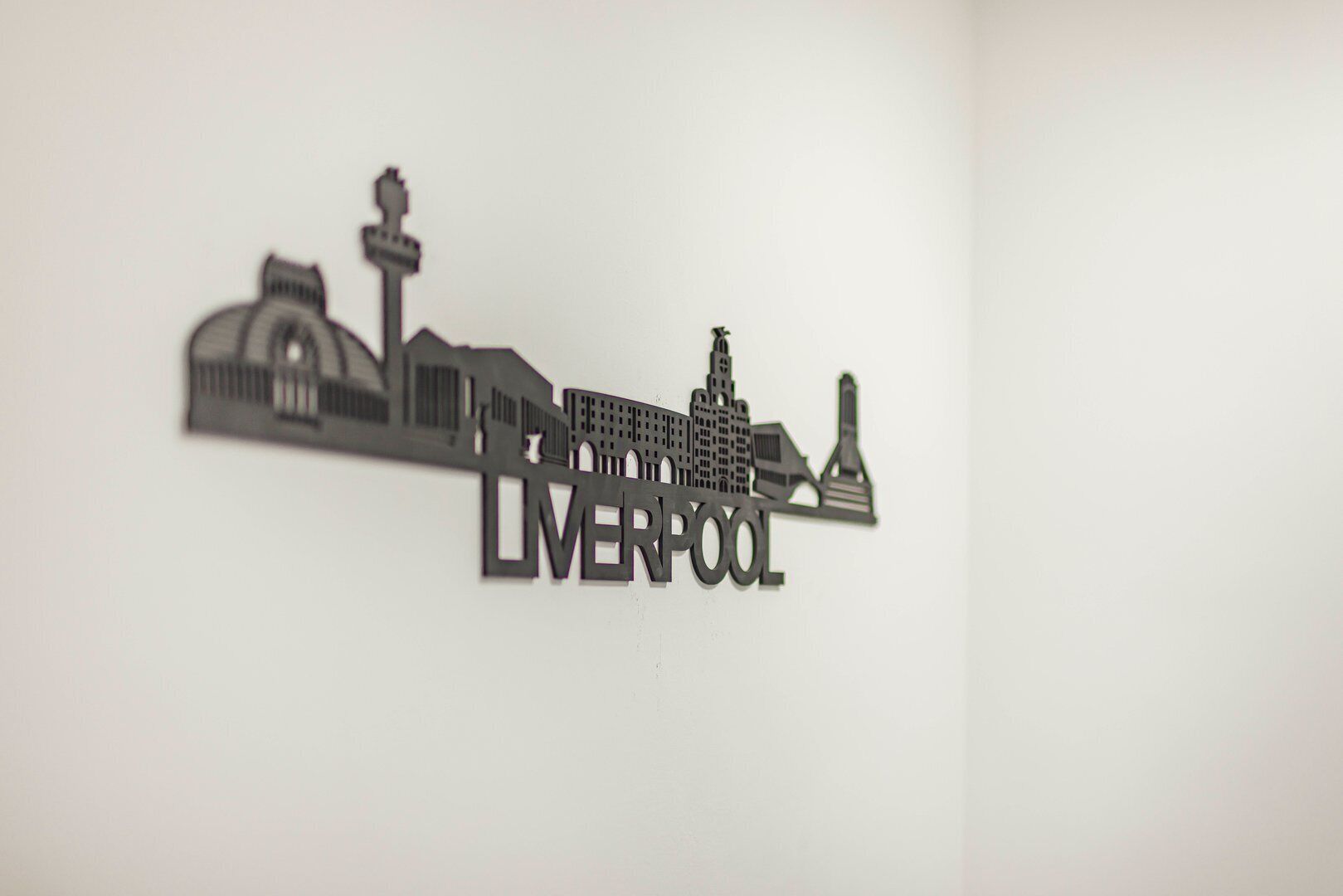 Een silhouet van een stadsgezicht, met de tekst 'LIVERPOOL' duidelijk in beeld.