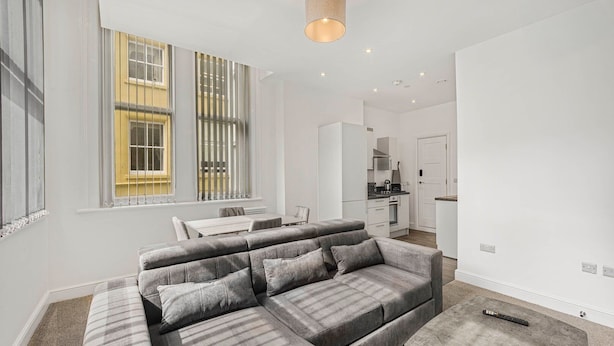 A modern living room with a sectional sofa, a dining area, and a kitchen in the background. - GuestReady – Stylish and central Liverpool retreat (Liverpool)