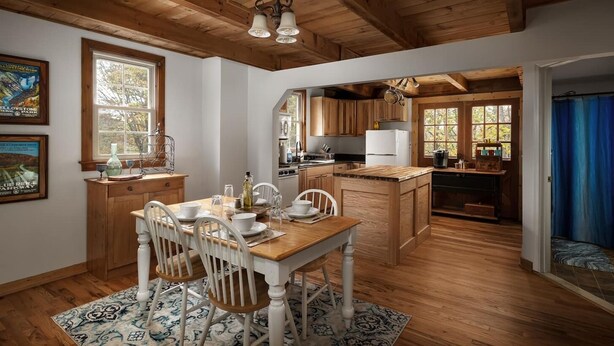 A wooden interior with a dining area, kitchen, and a view of the outdoors. - The Serenity Cabin | Firepit | Wineries | Hiking (Marshall)