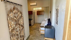 A hotel room with a bed, a chair, a ceiling fan, and a decorative wall hanging. - Apartasuite near the sea - Coveñas (Coveñas)