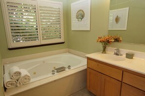 A bathroom with a bathtub, white towels, a sink, and a mirror. - The Sonoma Cottage will be your home away from home, the perfect getaway spot! (Occidental)