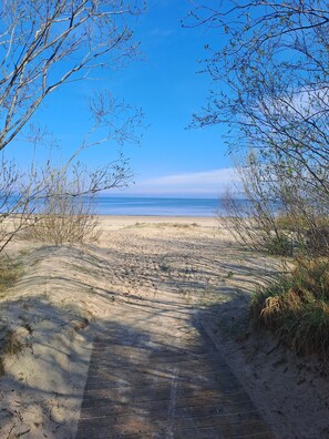 A sandy beach path leading to the ocean, surrounded by sparse vegetation. - Cozy apt, 100m beach, AC, workstation, balcony, backyard, self check-in, yogamat (Jūrmala)