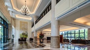 A spacious lobby with a high ceiling, large windows, and a central chandelier. - Jingyuan Shuizhuang Hotel (Shanghai)