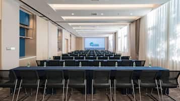 A conference room with a long table, chairs, and a projection screen at the front.