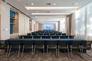 A conference room with a long table, chairs, and a projection screen at the front. - Jingyuan Shuizhuang Hotel (Shanghai)