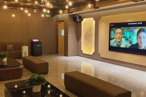 A lobby with seating, a reception desk, a digital screen, and a wall-mounted speaker. - Jingyuan Shuizhuang Hotel (Shanghai)