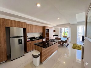 Una cocina moderna con una isla central, electrodomésticos de acero inoxidable y un comedor con vistas.