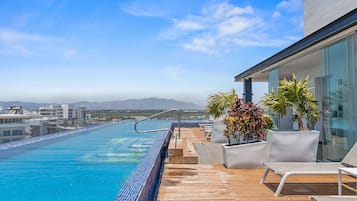 Een buitenzwembad, ligstoelen bij het zwembad