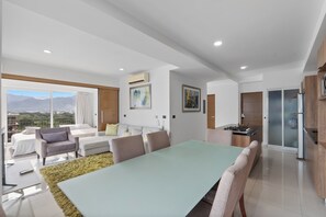 Un espacio moderno para vivir con una mesa de comedor, sofás y una cocina con estufa incorporada.