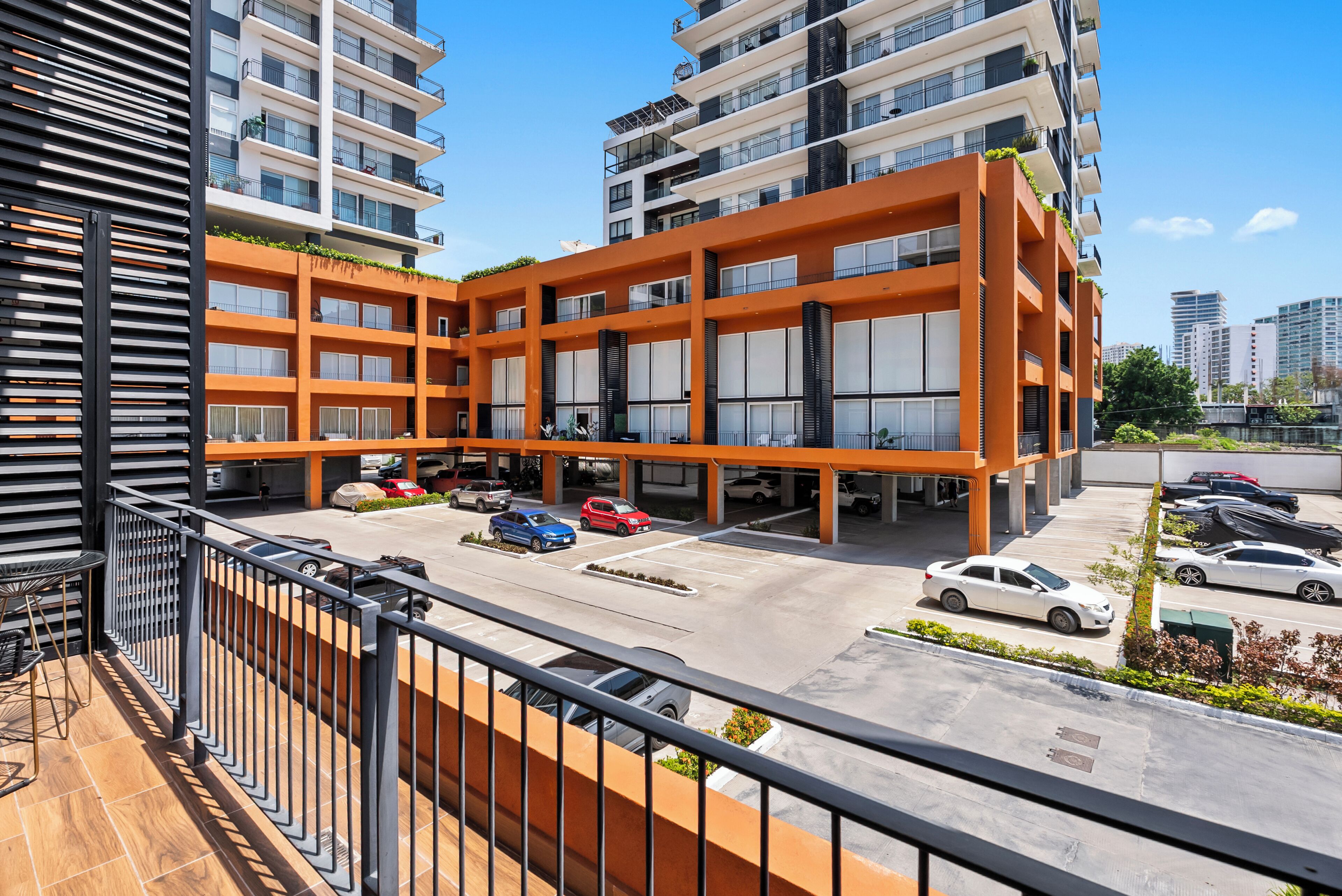 A multi-story parking structure with a modern design, surrounded by high-rise buildings.