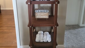 A wooden shelf with towels and a sign saying "Family is forever."