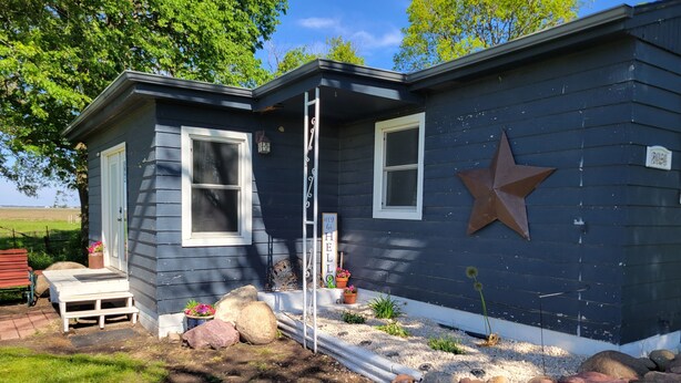 A house with a dark blue exterior, a white door, and a star decoration on the wall.