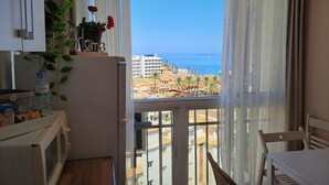 Un balcón con vista al mar y edificios.