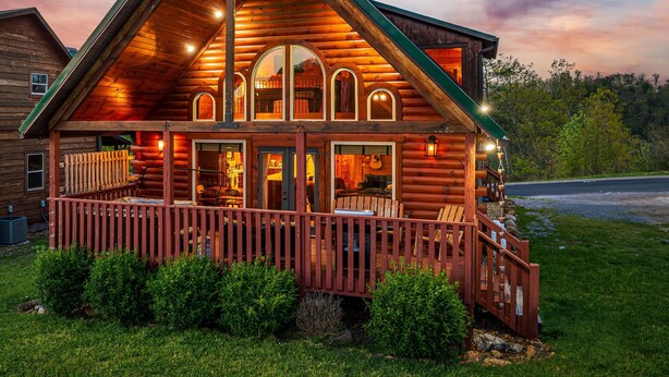 A log cabin with a porch, multiple windows, and a deck. - Beautiful Views, Spacious, Hot Tub, Easy Access Roads, & Free Attractions! (Sevierville)