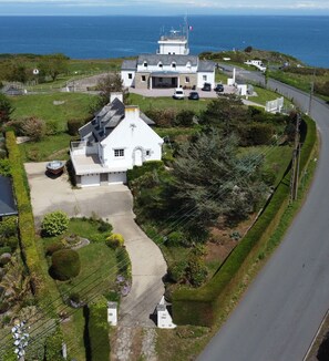 A coastal property with a main house, a smaller building, and a garage. There is a driveway leading to the main house, and a road runs alongside the property. - La Pastourelle - 10min à pied de la plage (Saint-Cast-le-Guildo)