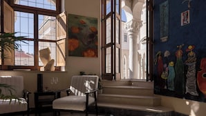 Une pièce dotée d’une grande fenêtre, d’une chaise, d’une table et d’un escalier menant à l’étage supérieur.