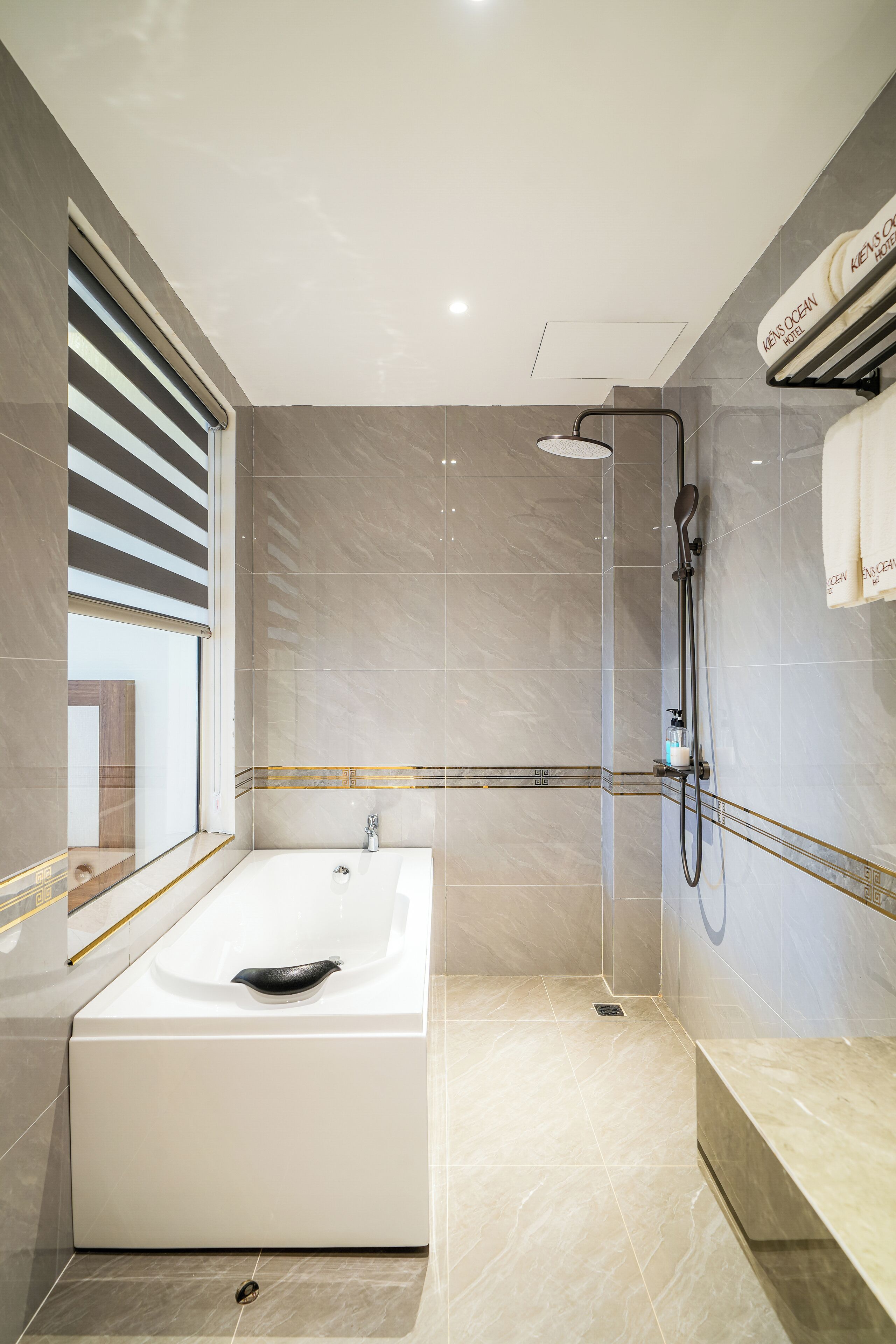 A modern bathroom with a large bathtub, a shower, and a vanity with a towel rack.
