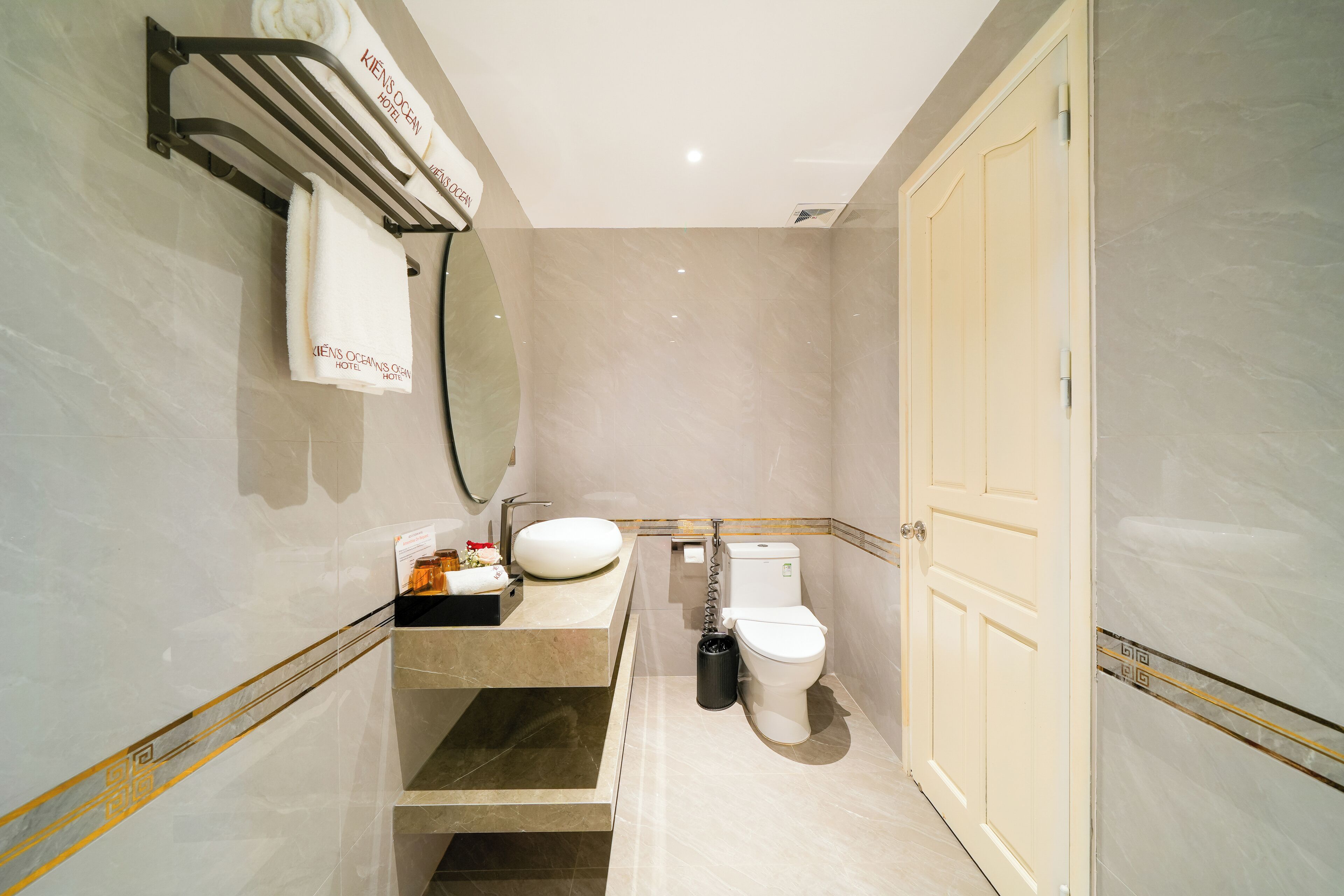 Baño con inodoro, lavamanos y perchero para toallas.