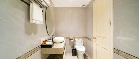 Baño con inodoro, lavamanos y perchero para toallas.