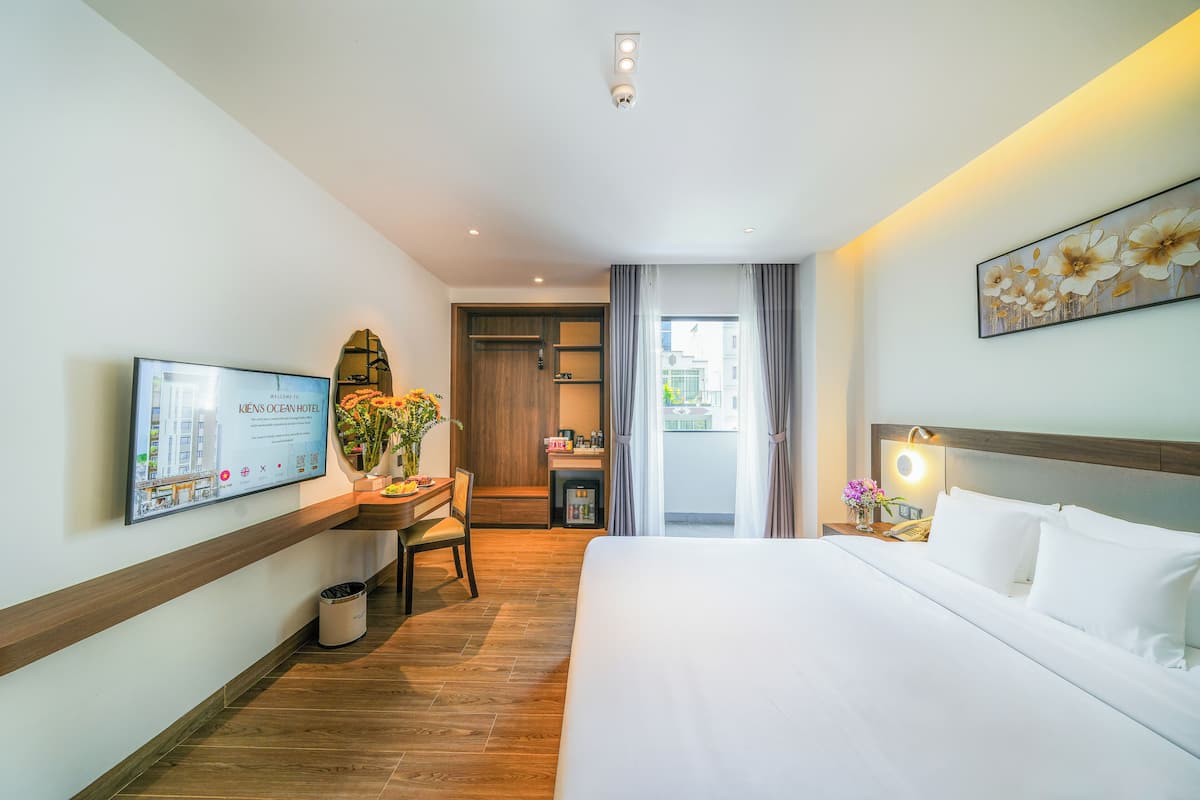 Une chambre d’hôtel comprenant un lit, un bureau, une chaise, une télévision et une salle de bain.