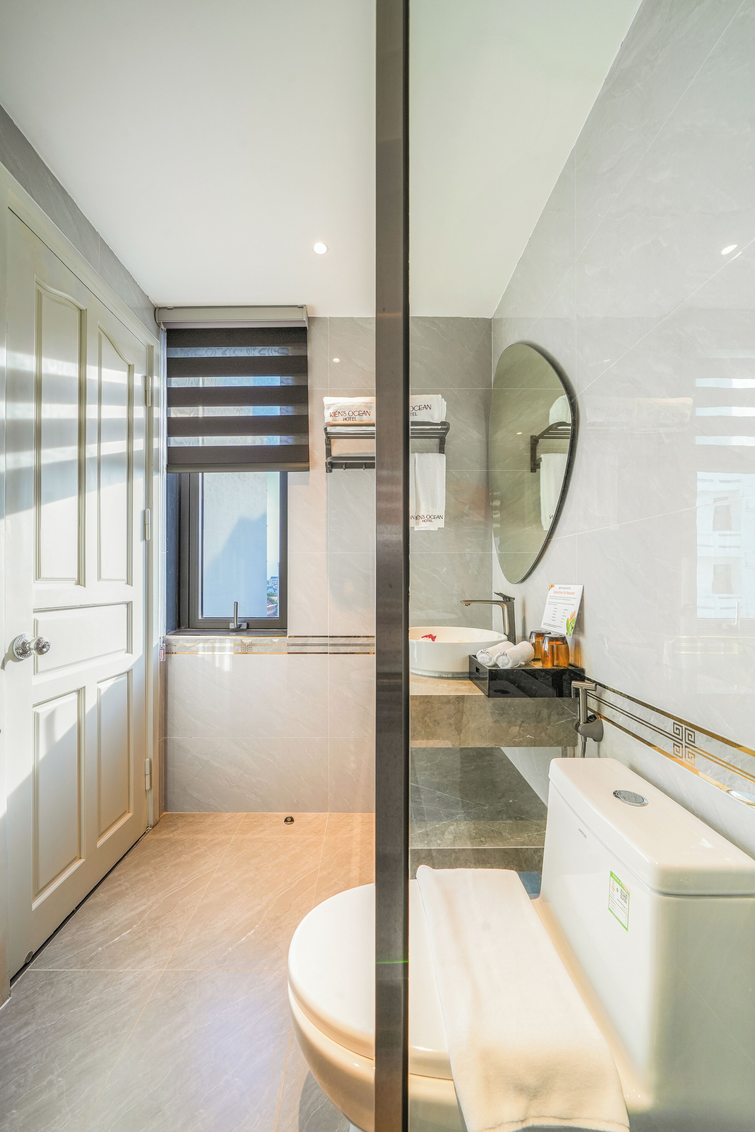 Une salle de bain moderne avec des toilettes, un bidet et un grand miroir.