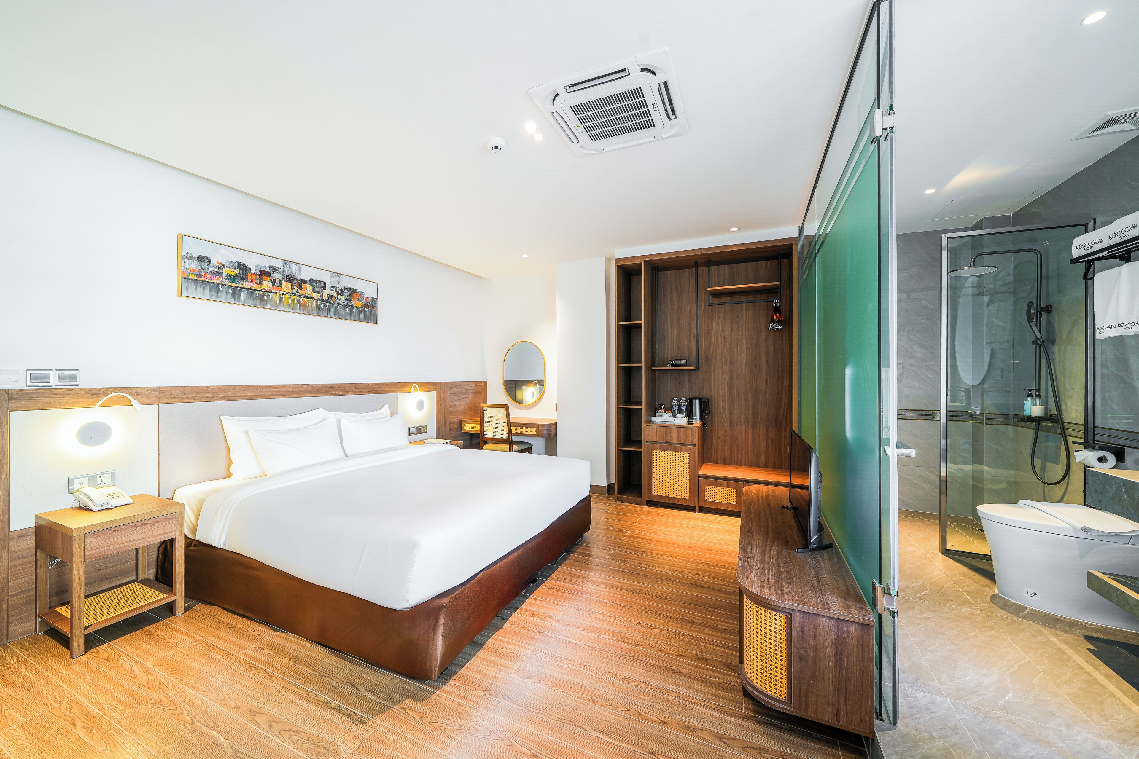Une chambre d’hôtel moderne dotée d’un grand lit, de tables de chevet, d’un miroir, d’une armoire et d’un espace douche.