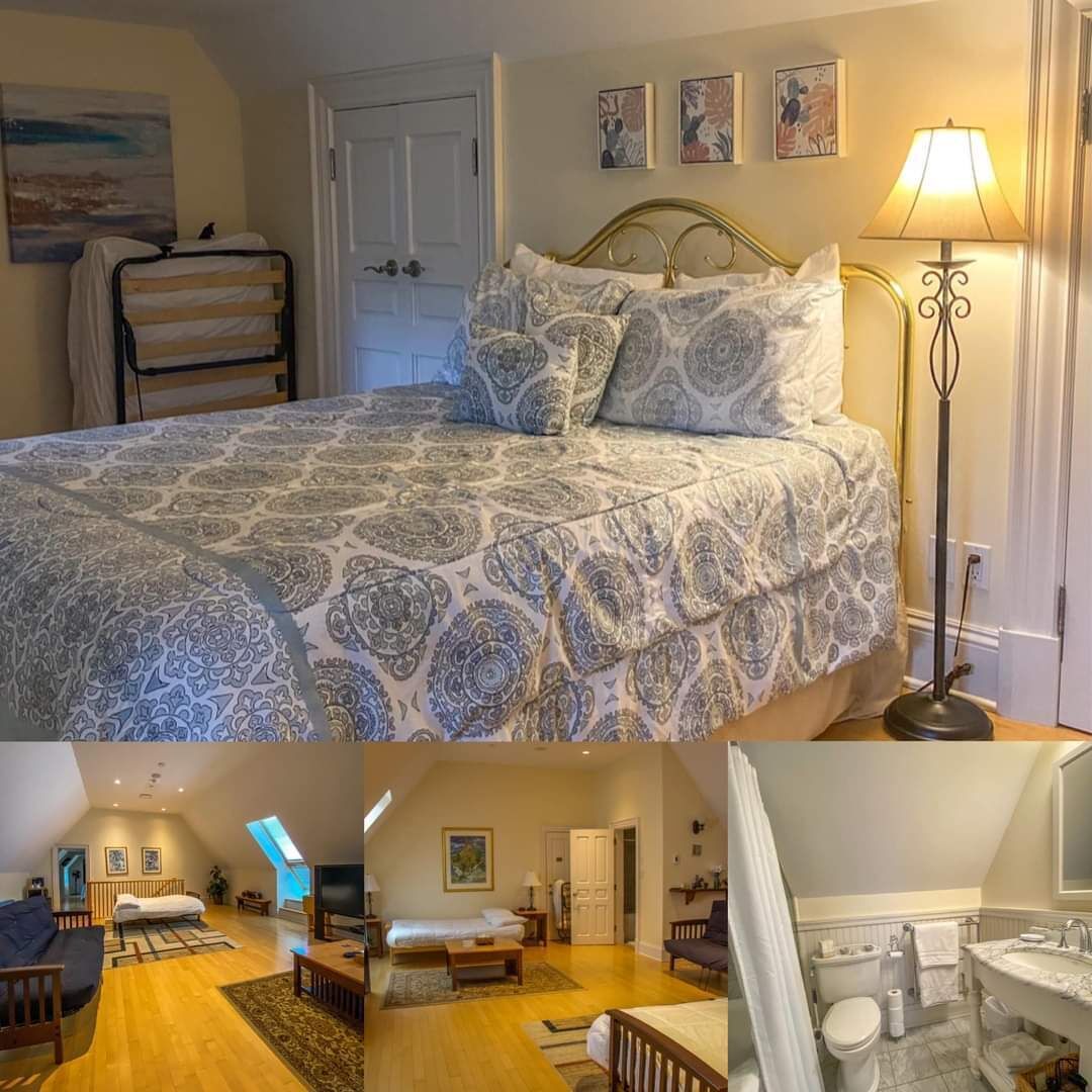 A bedroom with a bed, bedside table, lamp, and artwork.