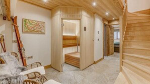 Un intérieur en bois comprenant un sauna, un escalier et un lit.